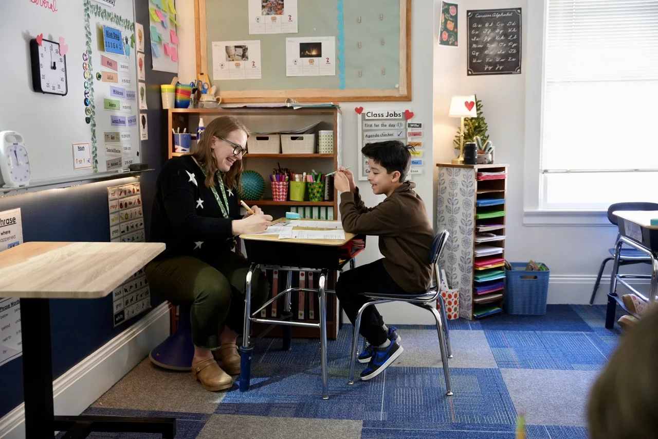 teacher working with student on literacy skills