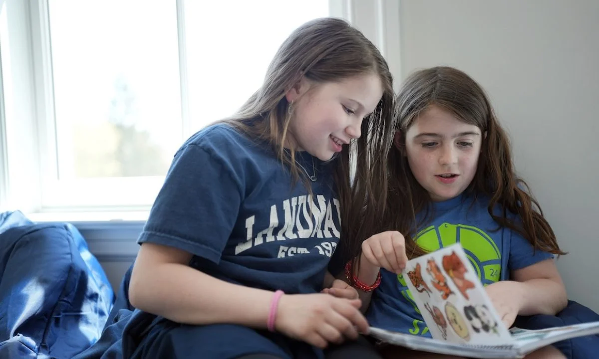 girls reading in chair together