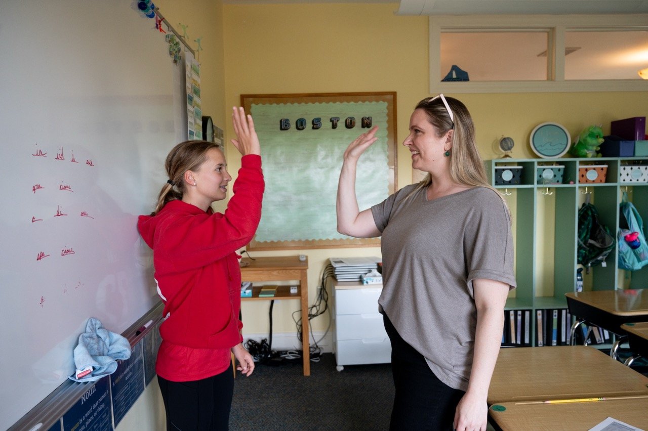 student and teacher high fiving