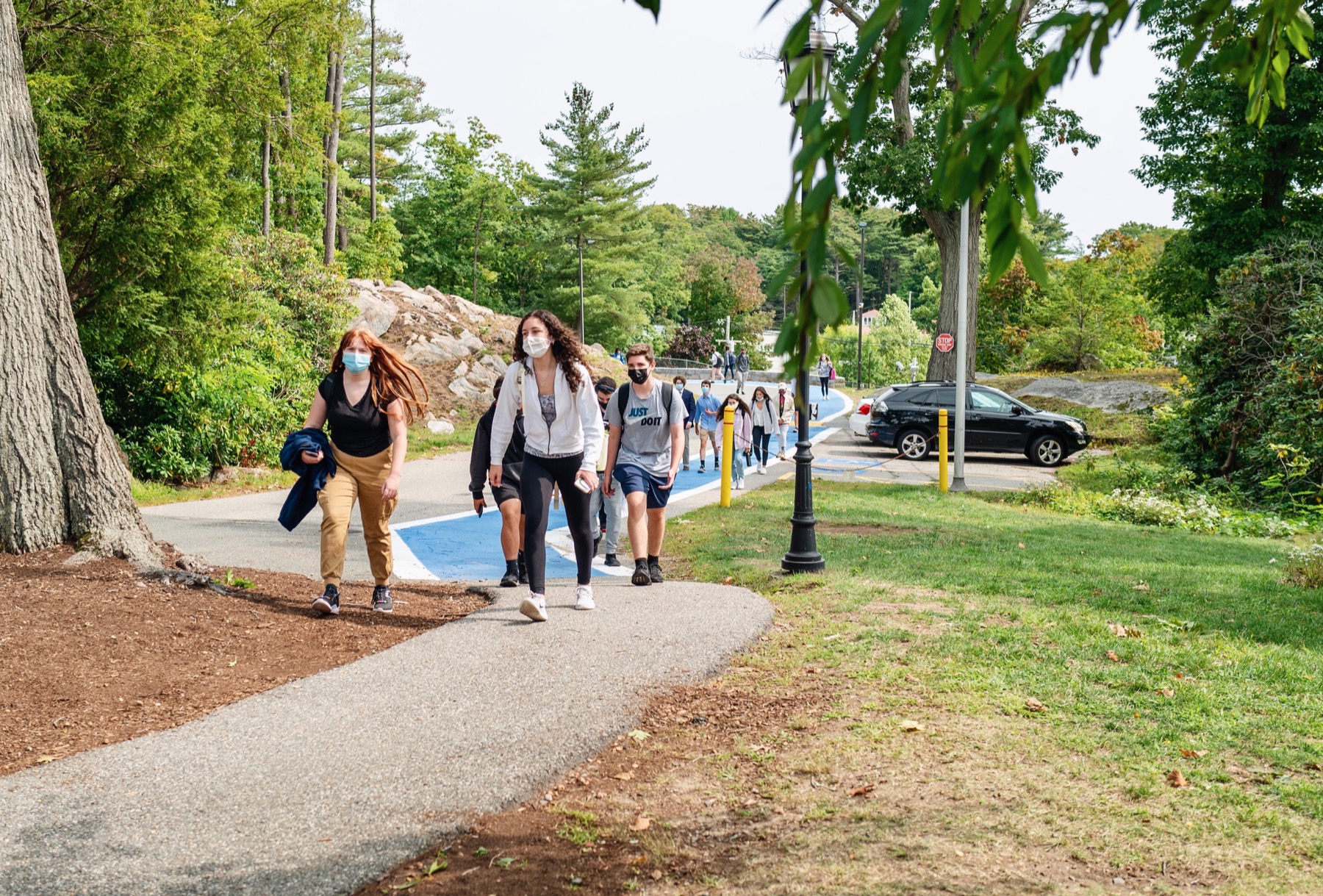 students in masks walking up hill